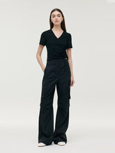 A lady wears black cargo pants.